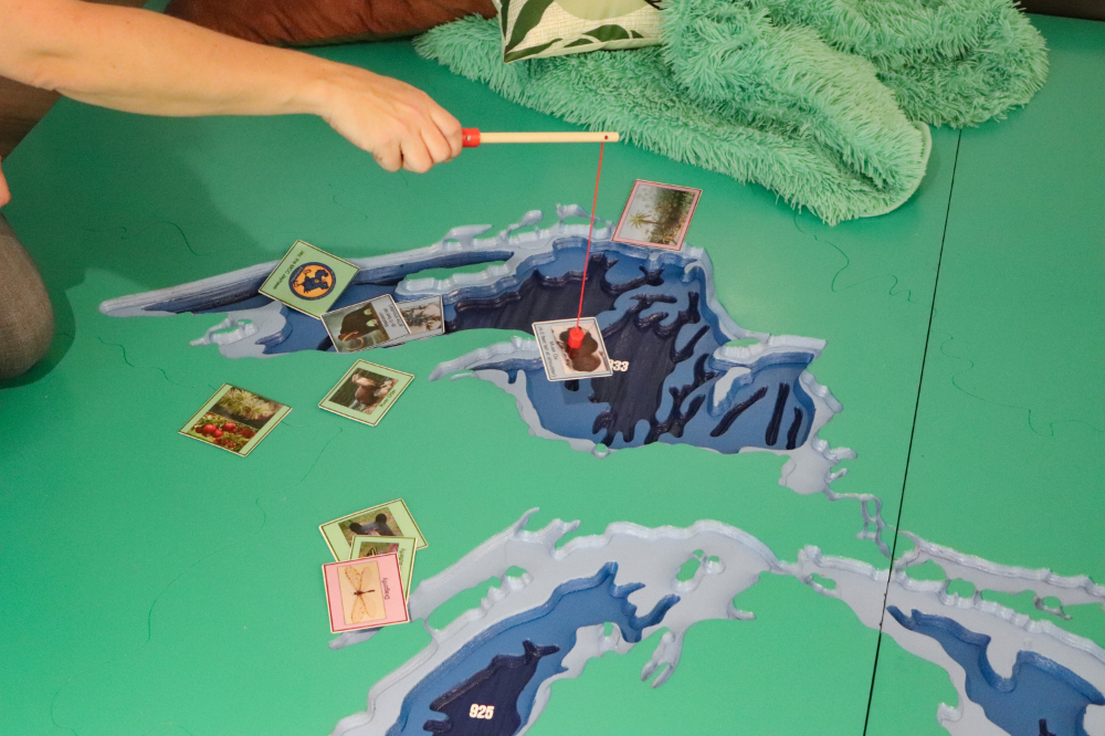 museum display, interactive game of kids using poles within a depressed map of Michigan