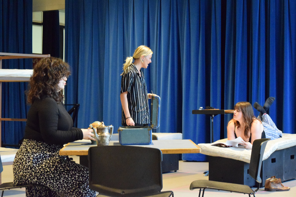 three people on stage during dress rehearsal