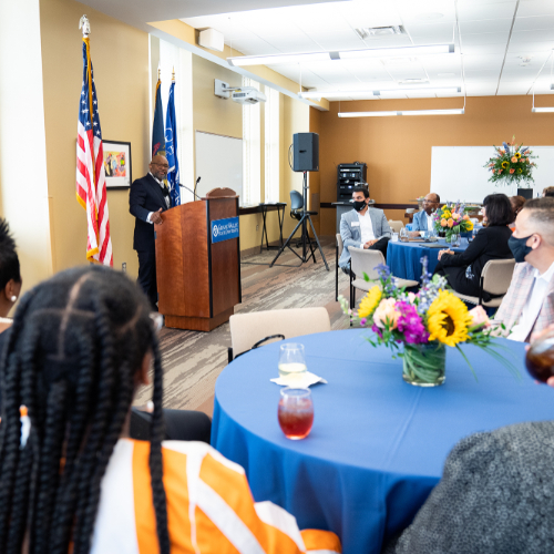 Speaking from a podium, B. Donta Truss, vice president for Enrollment Development and Educational Outreach, addresses the audience in the Detroit Center.