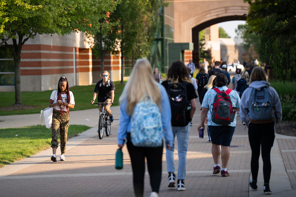 students walking near student services building arch