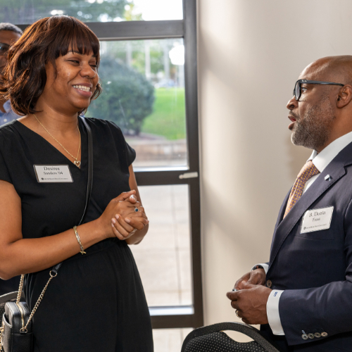 B. Donta Truss, vice president for Enrollment Development and Educational Outreach, talks with Desiree Sanders, '04, at the Southeast Michigan Ambassadors event.