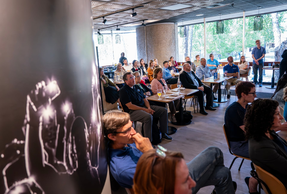 crowd of people seated listing to speaker in the Laker Club room