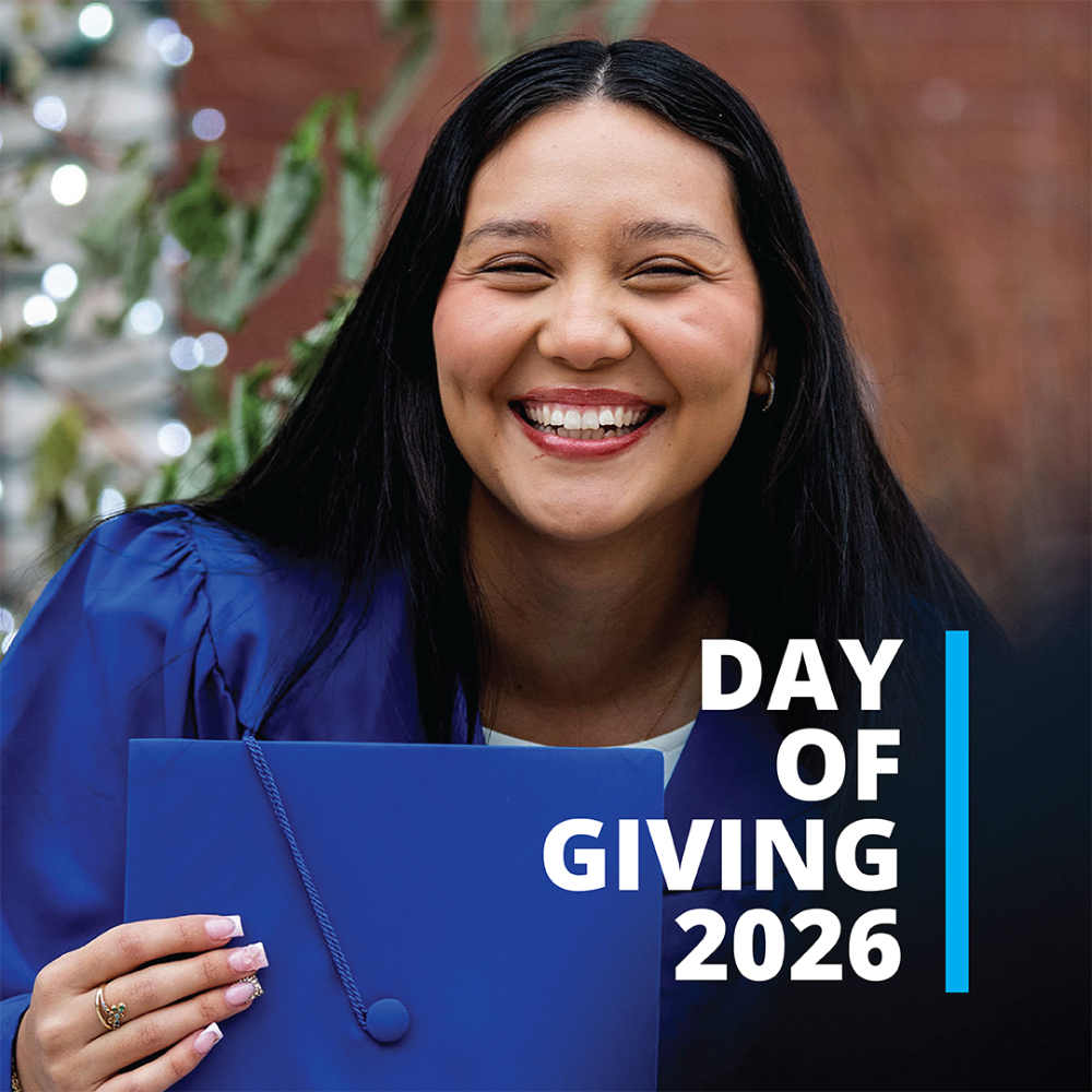 student in blue gown holding graduation cap, Day of Giving 2026