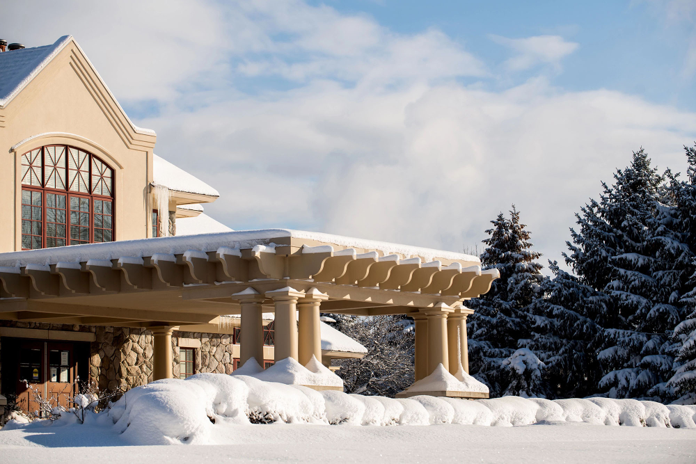 Alumni House and Visitor Center on a bright winter day, lots of snow in front lawn