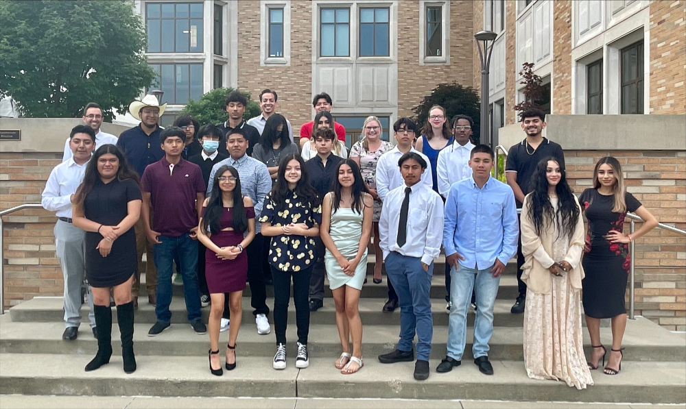 large group standing on steps, most in dressier clothes