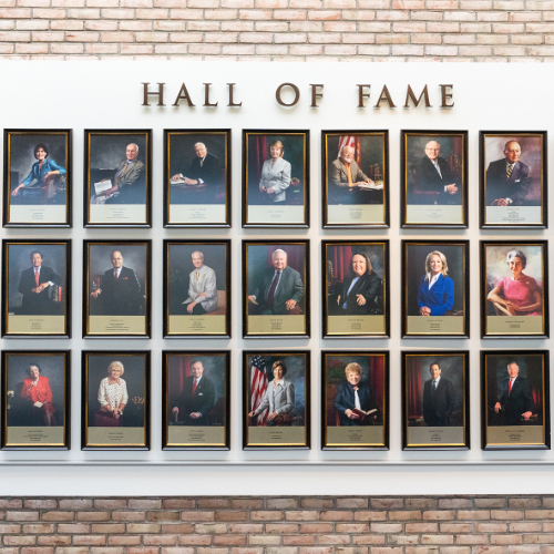 close up of portraits in the hall of fame that are three rows deep against a brick wall