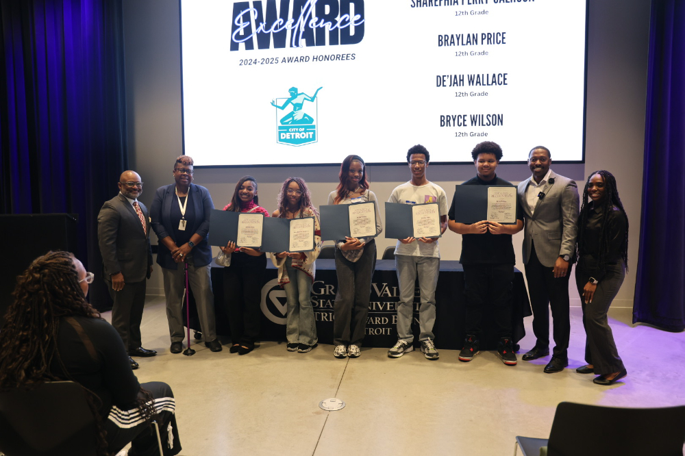 nine people standing in row, five students in center holding certificates