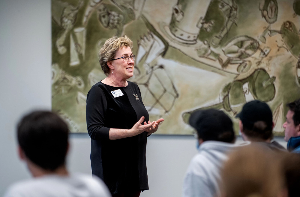 Michelle Miller-Adams speaks to an audience in a Kirkhof Center room.