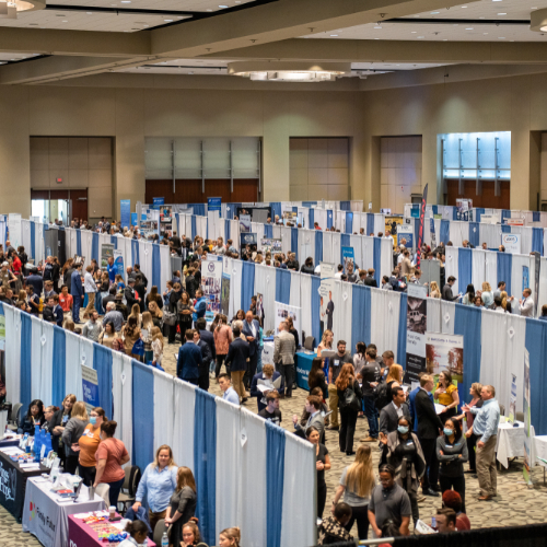 people walk among rows of booths at the career fair, held at the DeVos Place Convention Center