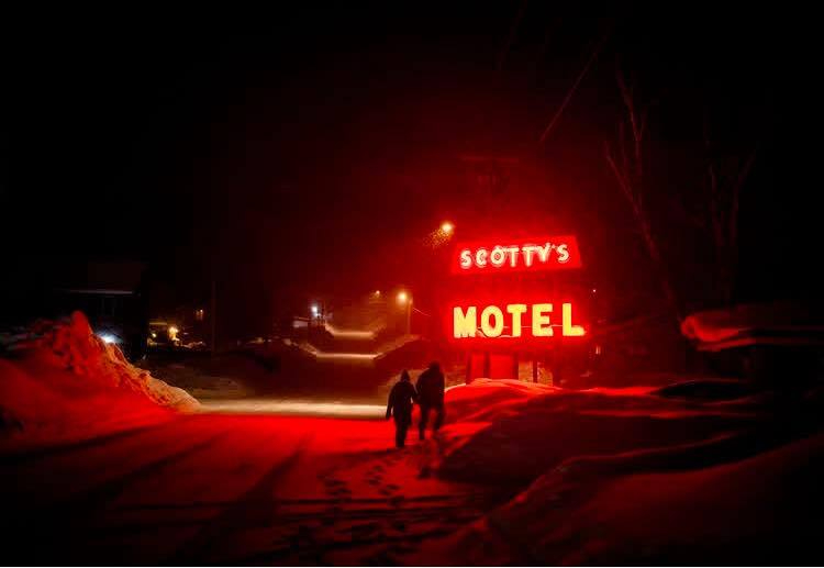 two people at night in snow, Scotty's Motel sign in red lights the snow