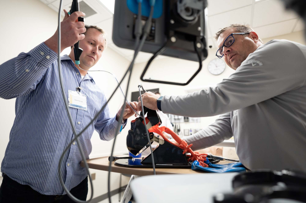 two people hold tubes on a device in the simulation center