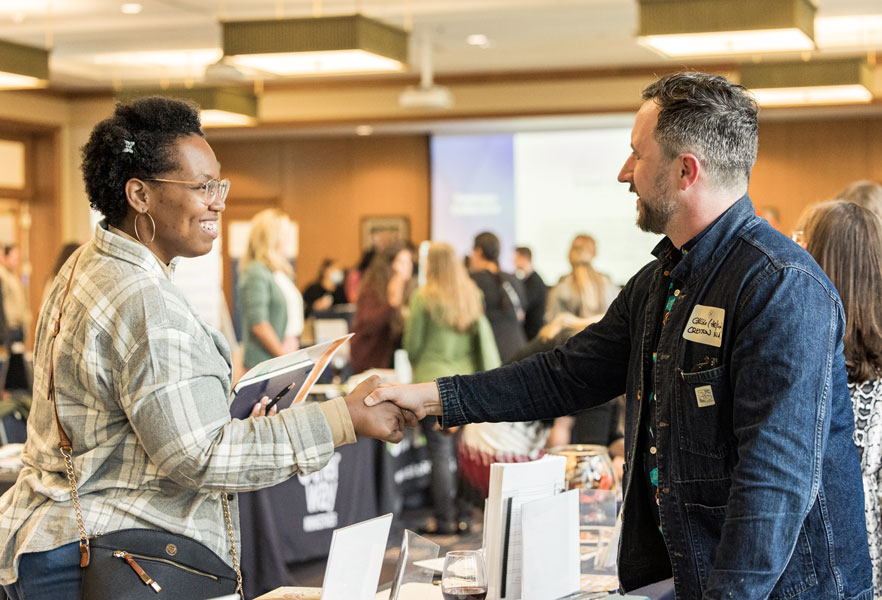 two people shaking hands over a table at a nonprofit clinic