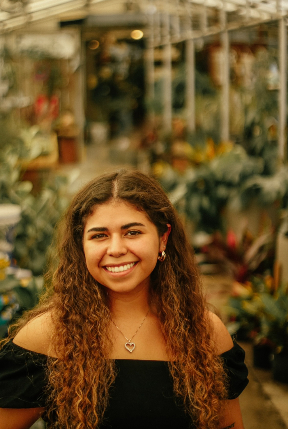 headshot of Marissa Acevedo, standing in a greenhouse