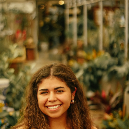 headshot of Marissa Acevedo, standing in a greenhouse
