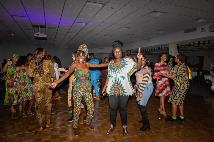 dancers in colorful African dress dance on a stage