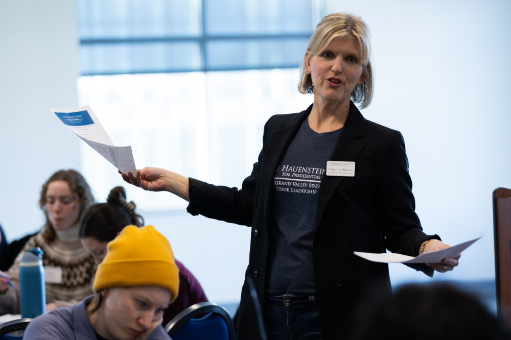 Christine Mutch gestures while holding papers in each hand