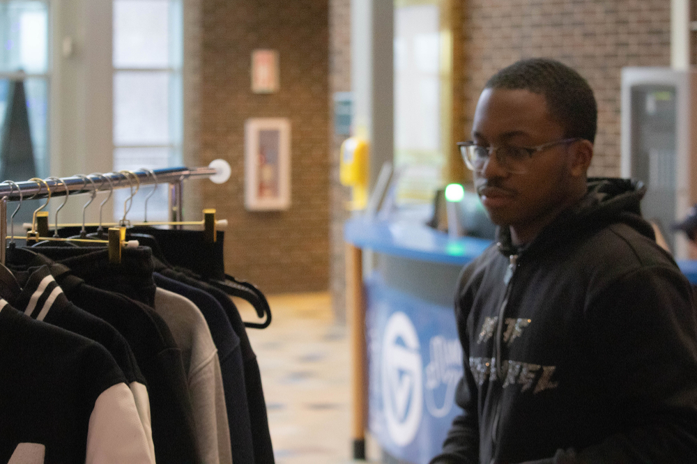 man at right looks at clothing rack in the Kirkhof Center lobby