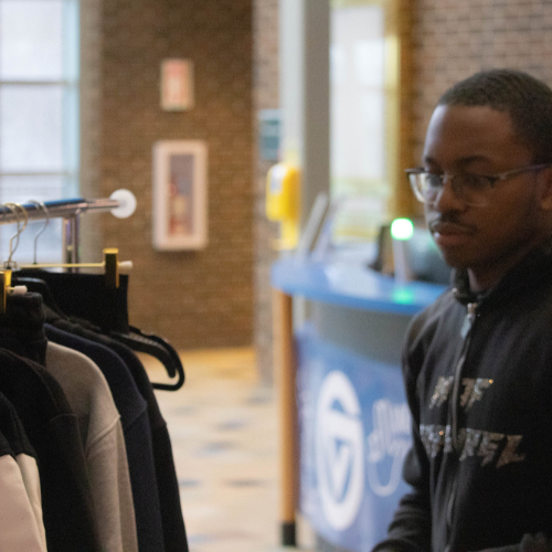 man at right looks at clothing rack in the Kirkhof Center lobby
