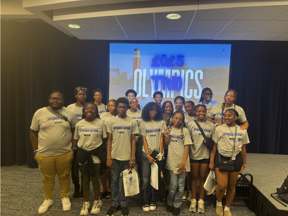 two rows of people in GVSU TRIO Detroit tshirts, 2025 TRIO Olympics on screen in background