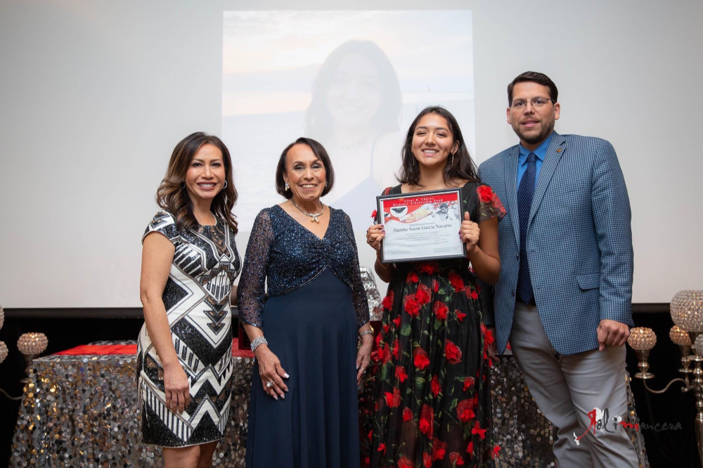 from left are Connie Dang, Lupe Ramos-Montigny, Danahe Garcia and Jesse Bernal standing in front of projection screen. Danahe holds a certificate.