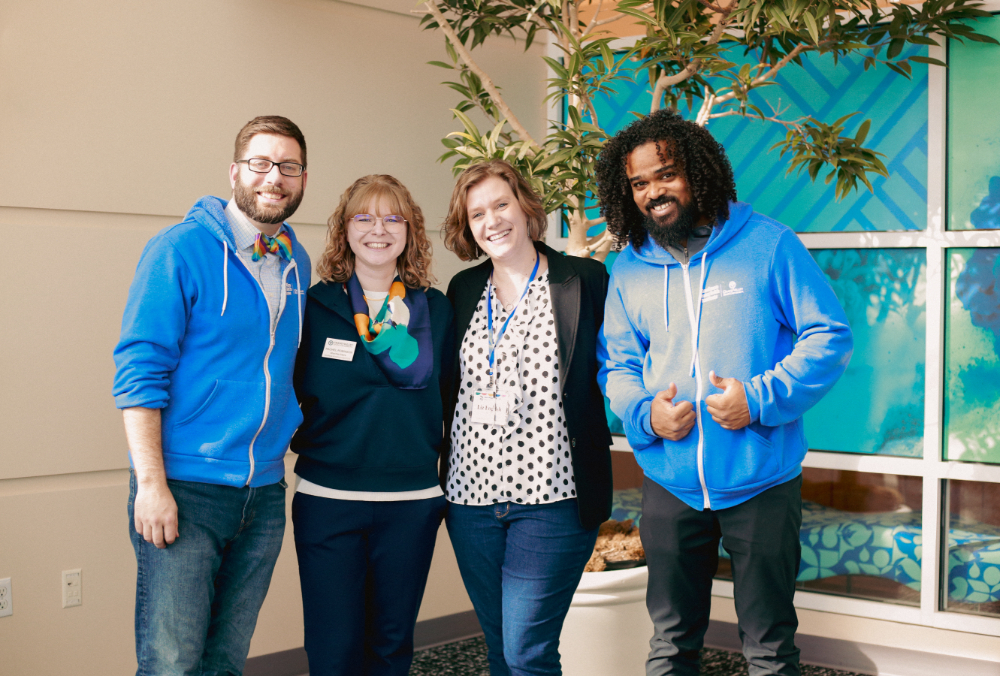 four people standing for photo