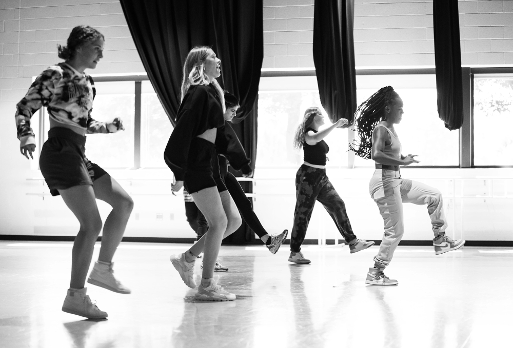 five students dance hip hop style in a dance room in the Performing Arts Center