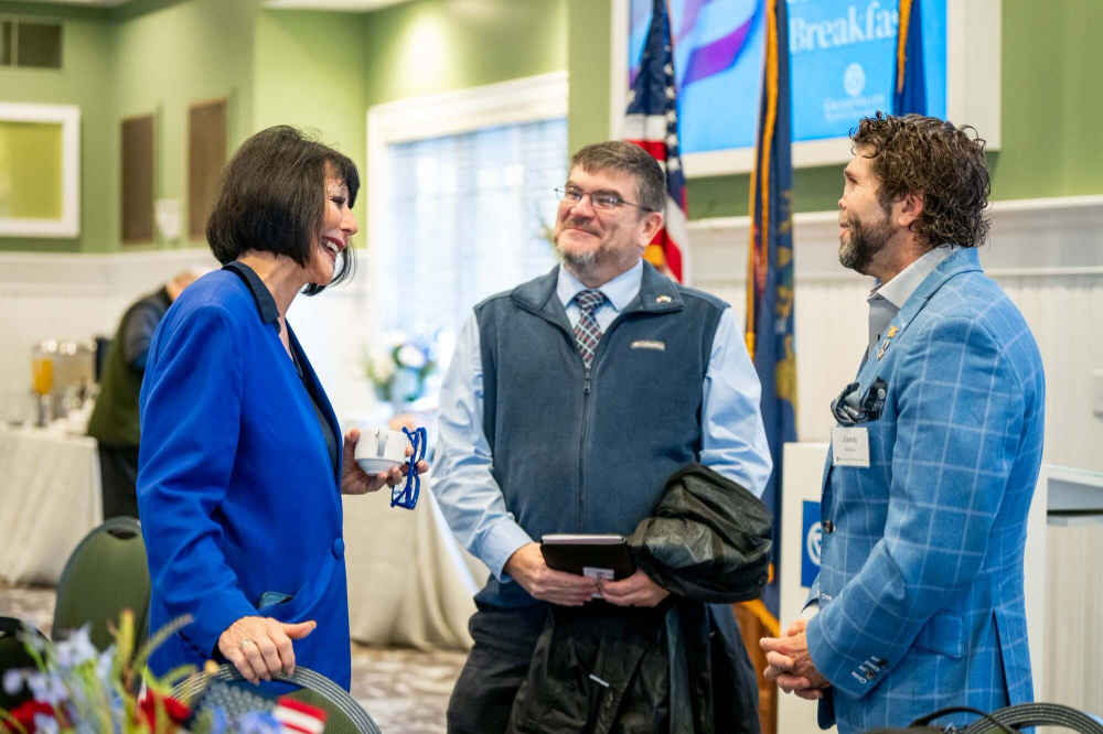 President Mantella on left standing to talk with two men at the veterans breakfast