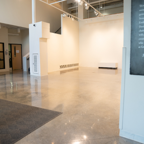 empty gallery space, hallway entrance on left side, sign dedicated to Stuart Padnos on right