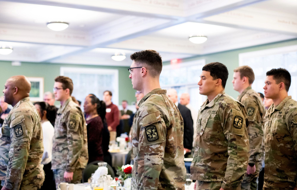 students in military camoflague uniforms stand for the national anthem during a breakfast on Veterans Day in the Kirkhof Center