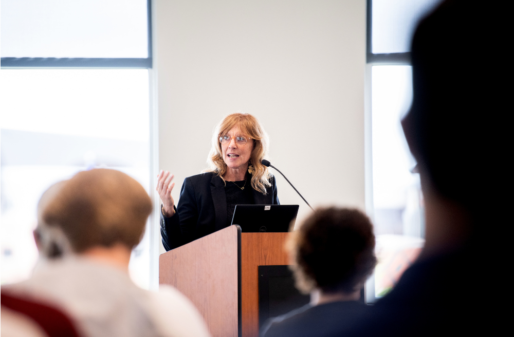 Melissa Baker-Boosamra, associate director of Student Life-Civic Engagement, speaks at the podium during a Thompson Scholars event in September.