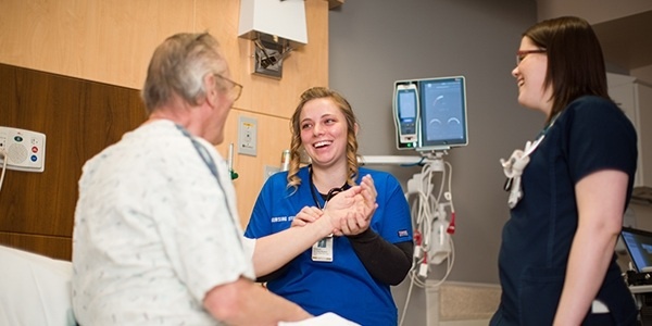Nursing student helping patient.