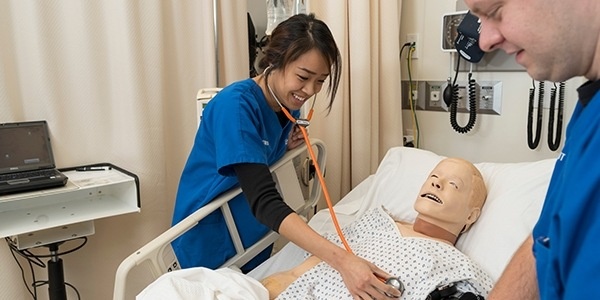Two students practicing on a simulation mannequin.