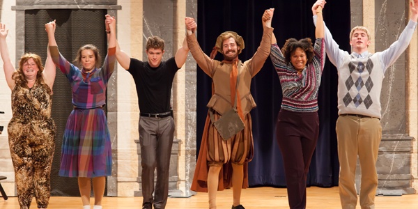 Students on stage during a Shakespeare play.