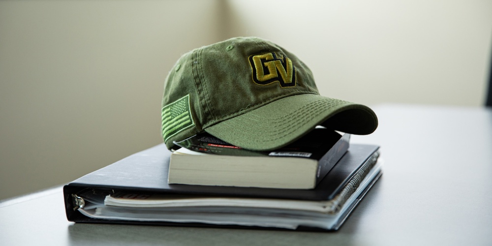 Green Grand Valley Hat on top of books