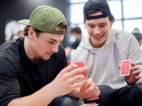 Players focus on stacking playing cards