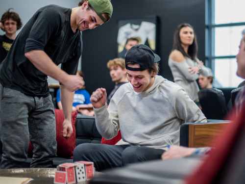 Players fist bump to celebrate stacking cards successfully