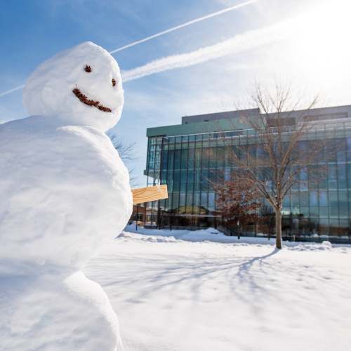 A snowman in front of the library