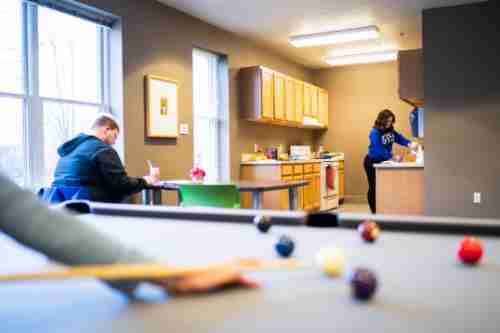 Students play pool, study and cook in a downtown living center common area