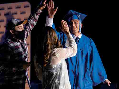 Graduate high fives his family