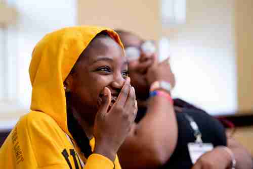 Two students laugh together