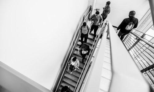 Students walk down a staircase. Photo is taken from above