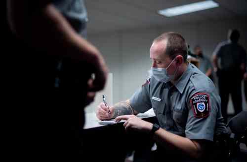 Police academy student writes at a table