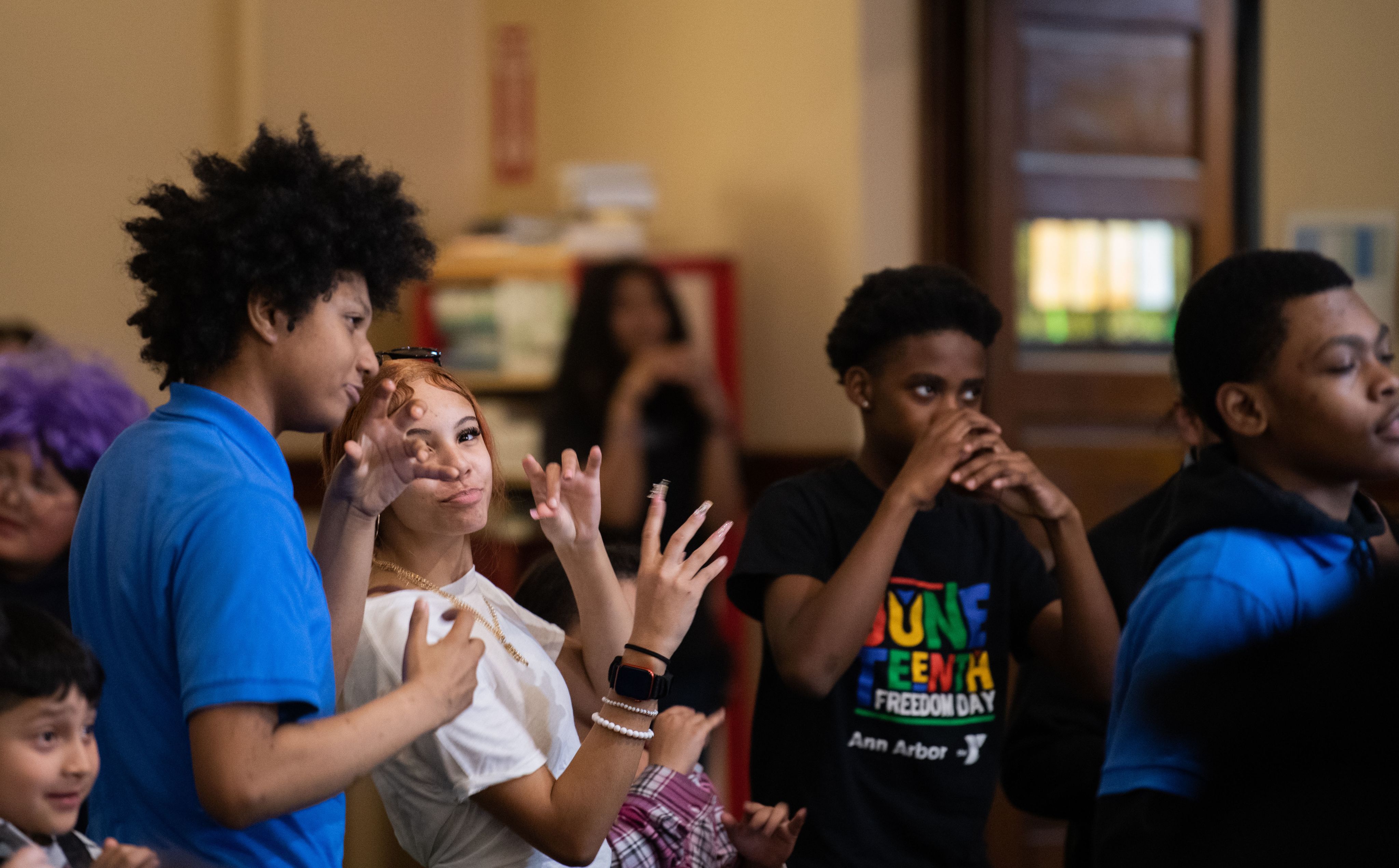 group of young students pretend to play musical instruments, like horns
