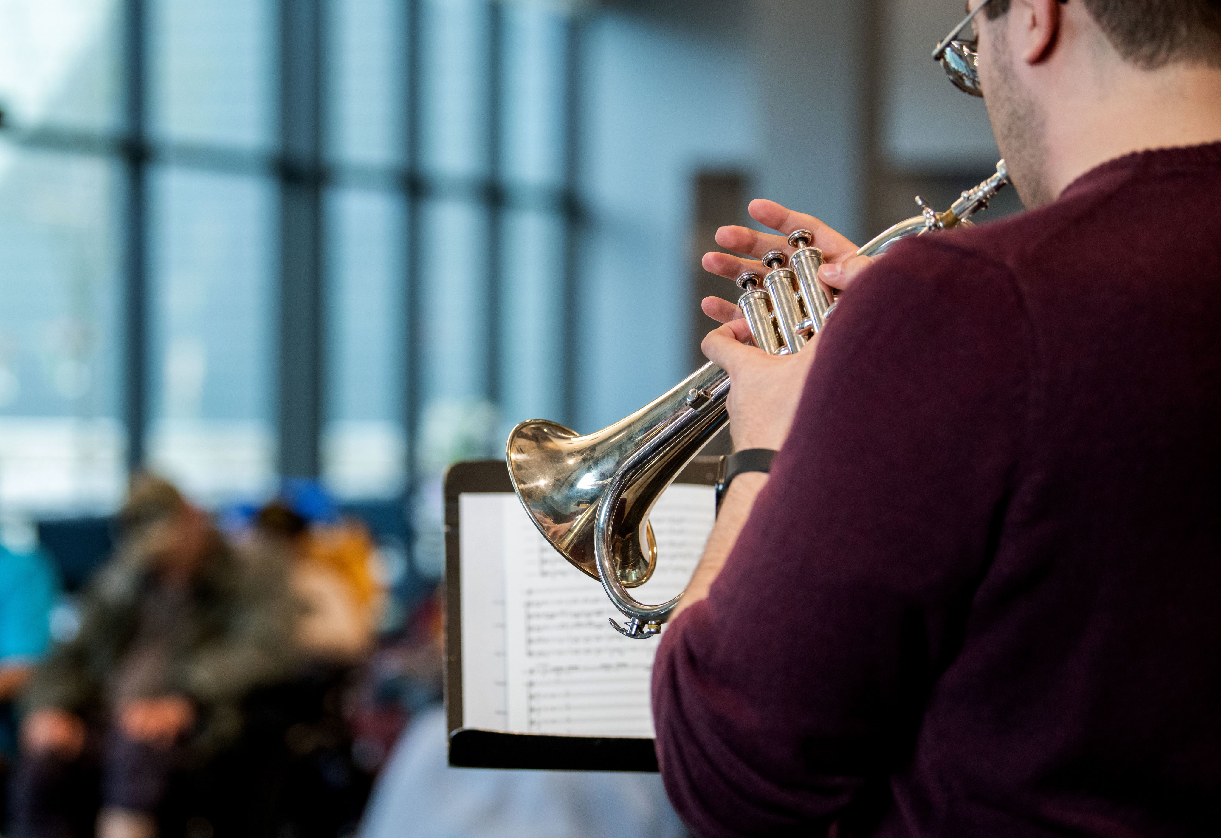 A trumpeter plays music, music stand and sheet music in front