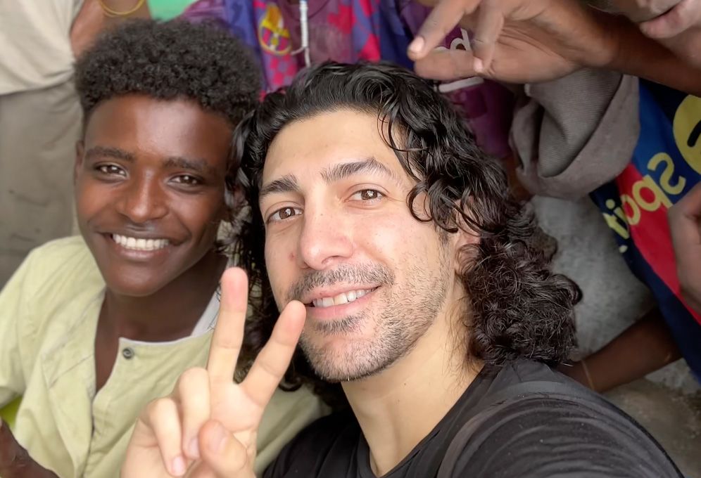 Michael Zervos showing peace sign next to young person