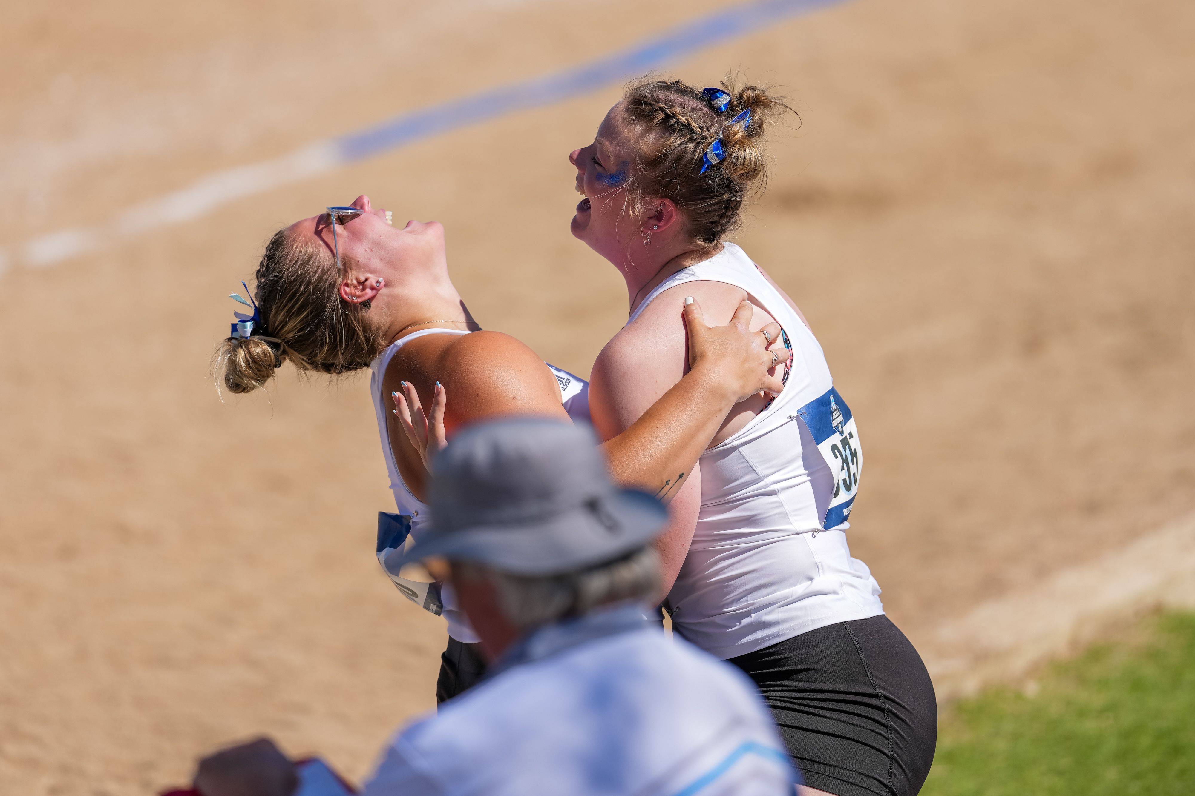 two track athletes embrace and are smiling