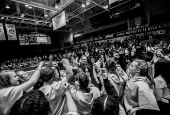 wrestling team puts hands in team huddle before matches begin