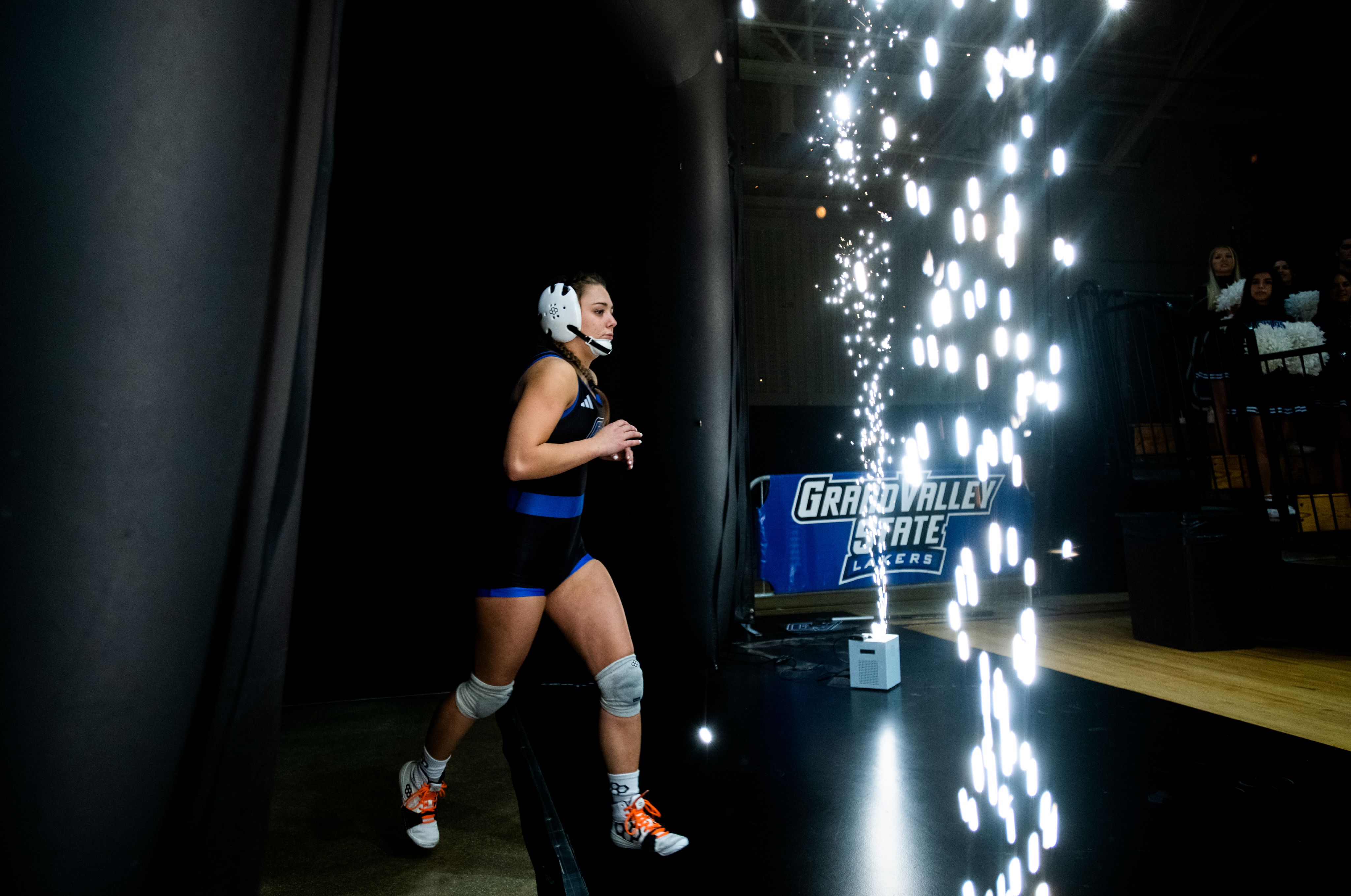 women wrestler runs out to court, sparkler lights going off