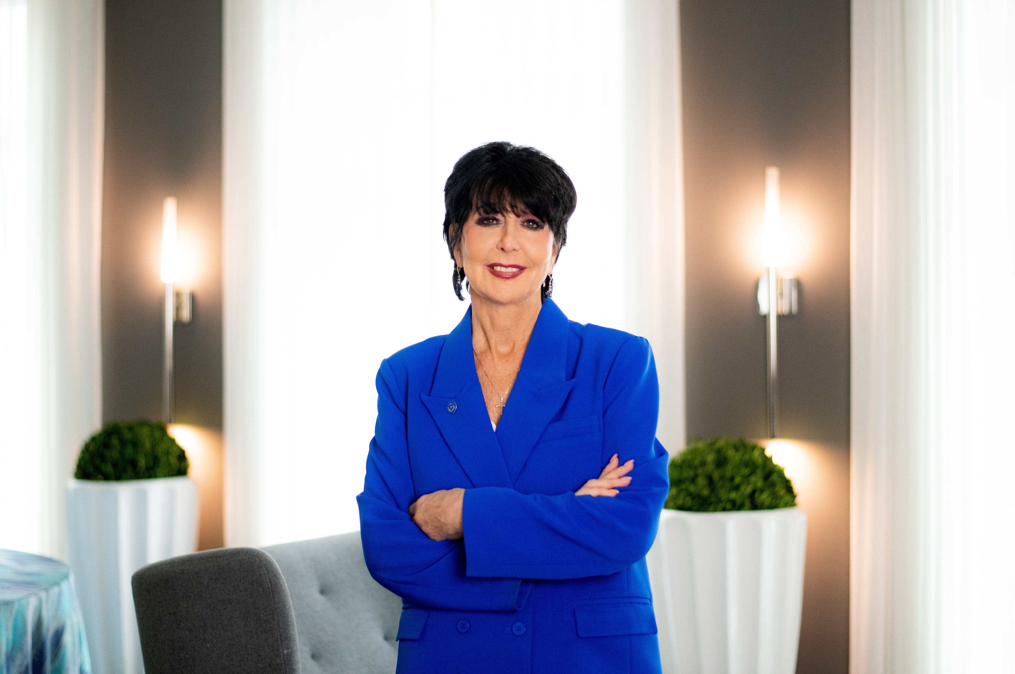 President Mantella in blue jacket standing with her arms folded