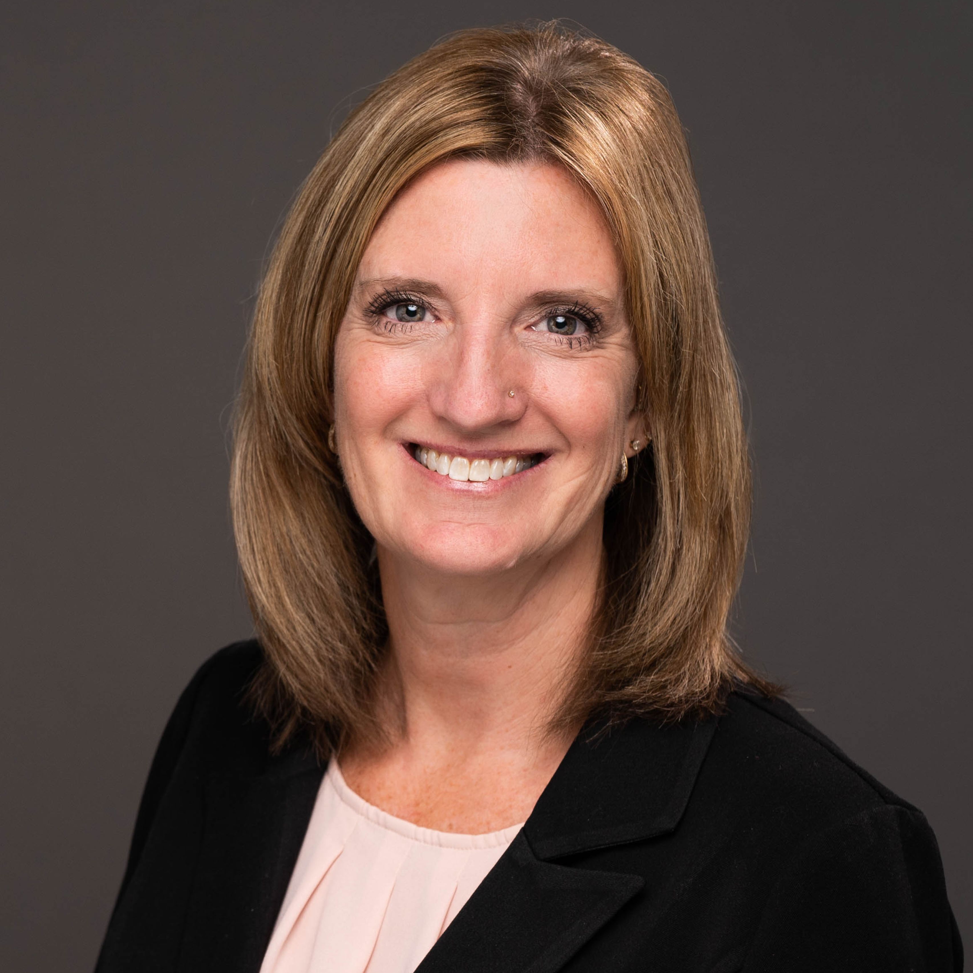 Ronda Huster in dark blazer, smiling